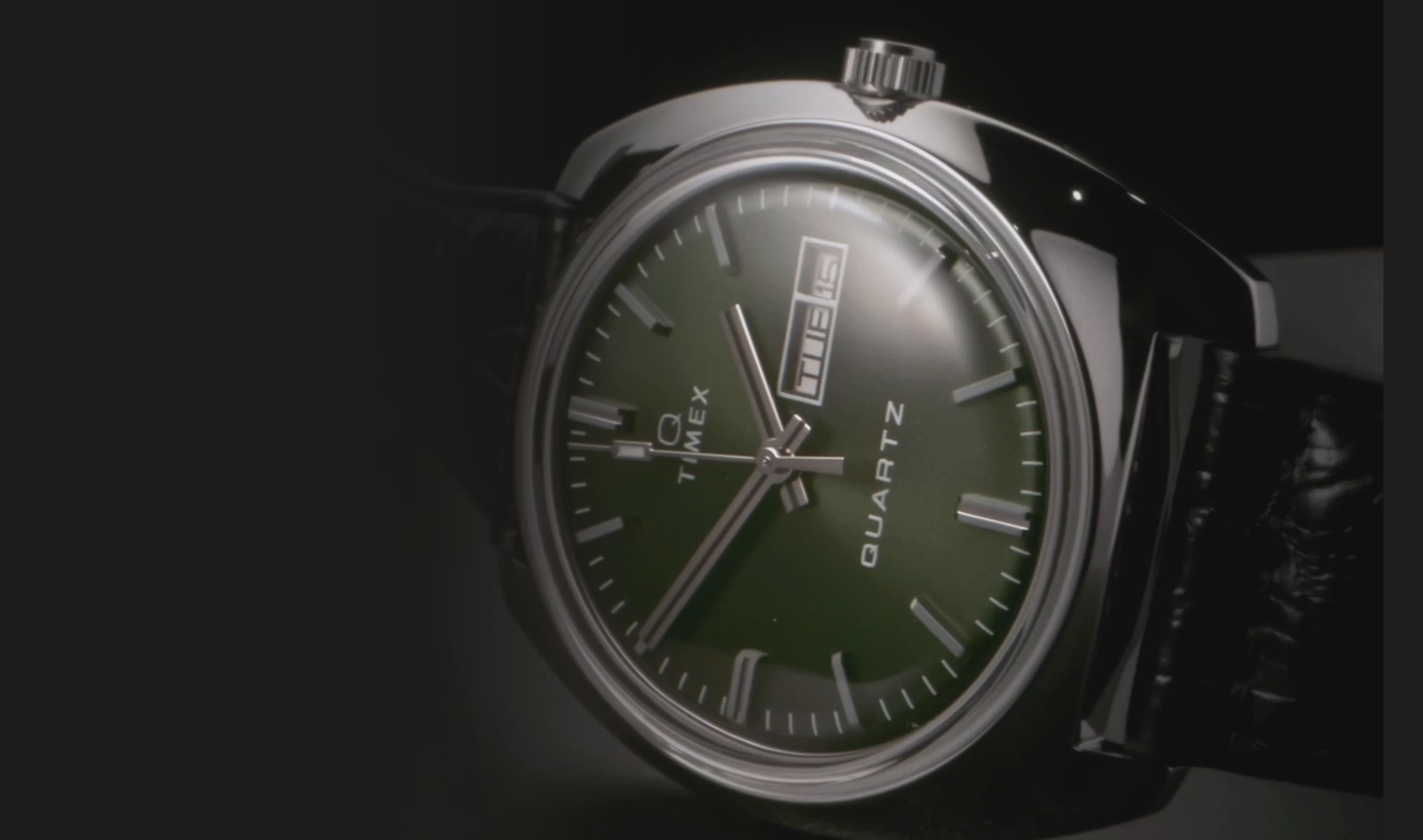 A close-up video showcasing the Q Timex 1978 Day/Date watch, highlighting its vintage-inspired design with a rectangular stainless steel case, brushed silver-tone dial, and day-date display at 3 o’clock. The watch features a domed acrylic crystal and a two-tone stainless steel bracelet, reflecting the iconic late-70s aesthetic. The video smoothly transitions between angles, emphasizing the watch’s polished details, textured dial, and retro elegance.
